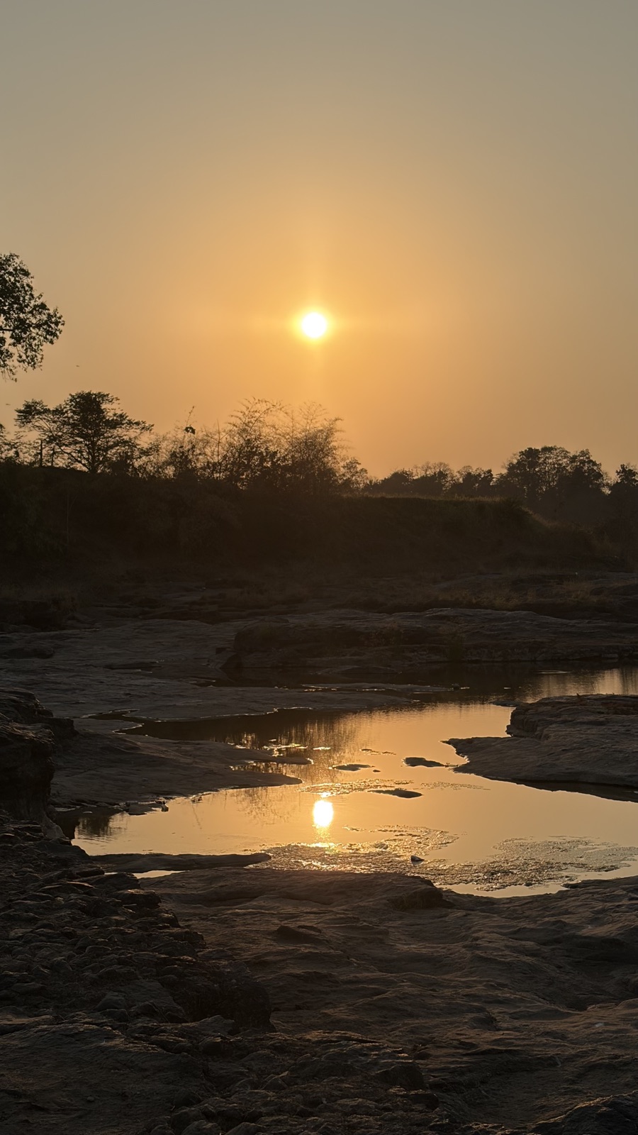 Sunset over a rocky riverbed in the Dangs