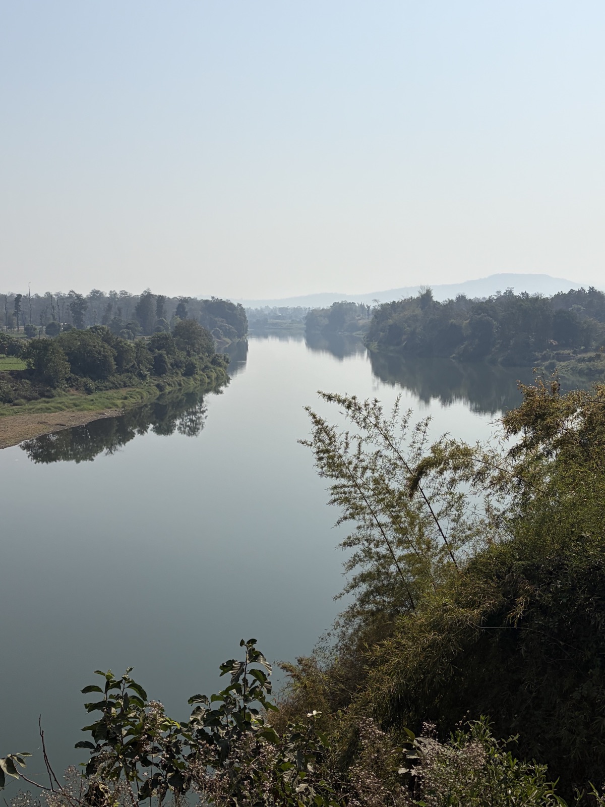 A calm river winding through green banks in the Dangs