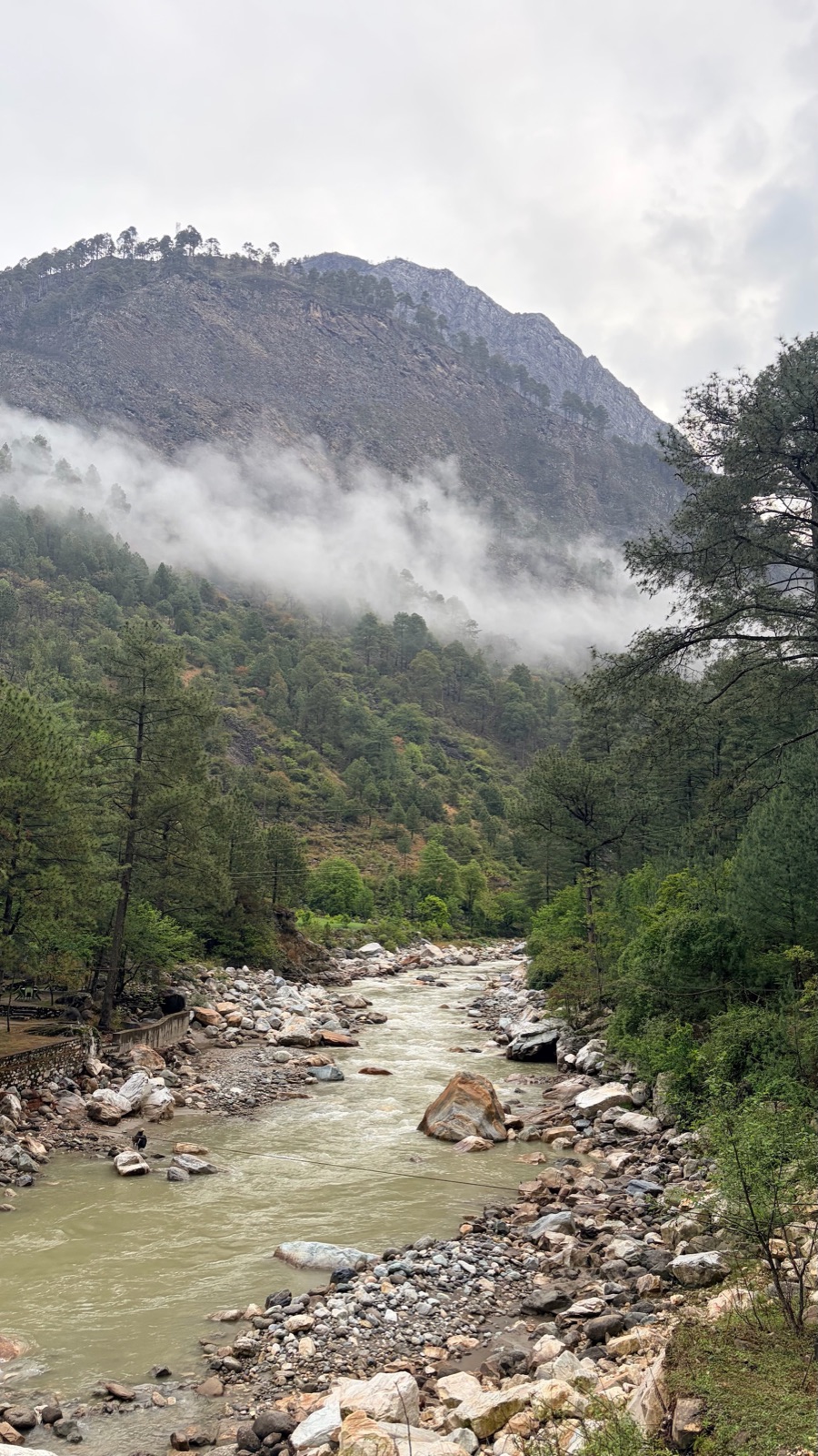 The Tirthan river winding through a misty valley