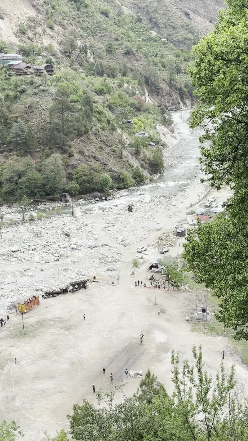 A view over the Tirthan riverbed where children play cricket